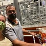 couple wearing masks pushing supermarket trolley