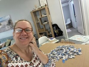 woman sitting with jigsaw puzzle pieces